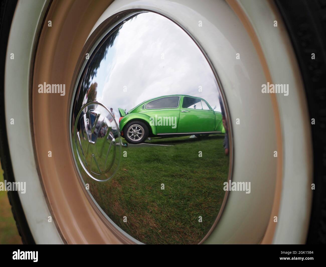 Riflesso di un berretto VW restaurato e personalizzato nel mozzo di un altro Beetle Foto Stock