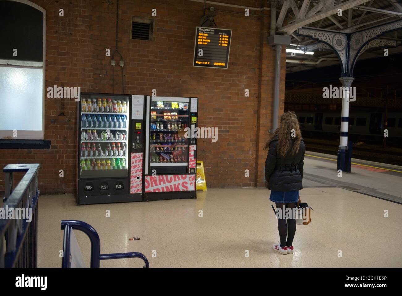 Doncaster, Regno Unito, 22 maggio 2021: La giovane donna Lone studia la stazione ferroviaria di doncaster partenza a bordo di notte dopo una cancellazione Foto Stock