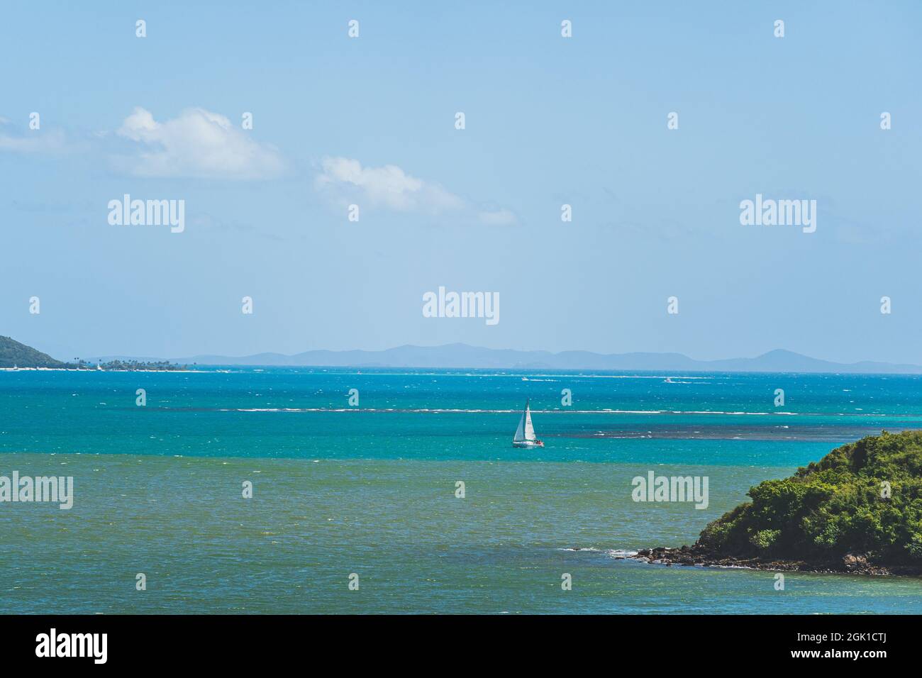 Barca a vela in lontananza nel Mar dei Caraibi al largo della costa di Puerto Rico Foto Stock