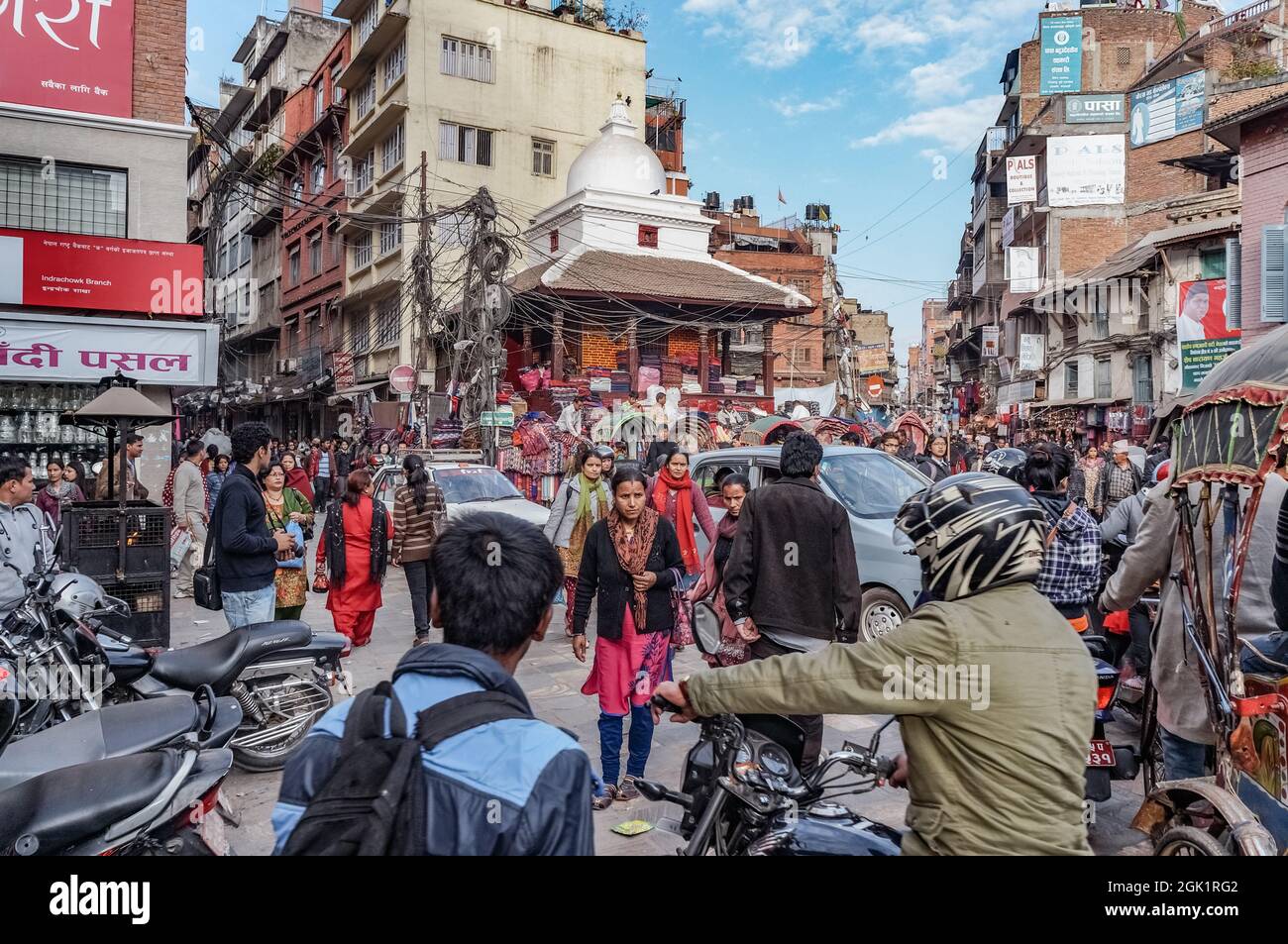 Biciclette, pedoni e auto: Traffico occupato a Indra Chok piazza nel centro di Kathmandu, Nepal Foto Stock