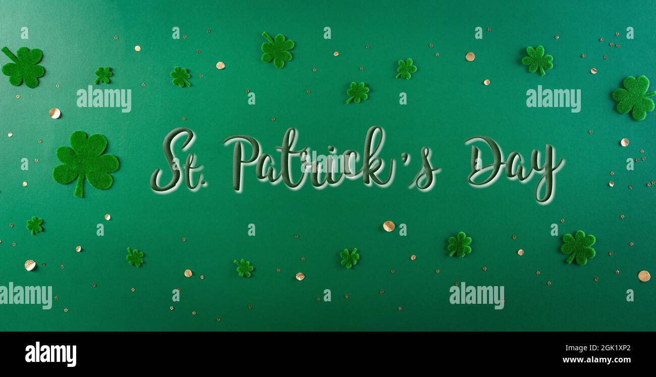 Felice San Patricks Day decorazione concetto. Disposizione piatta, vista dall'alto delle foglie di trifoglio su sfondo verde Foto Stock