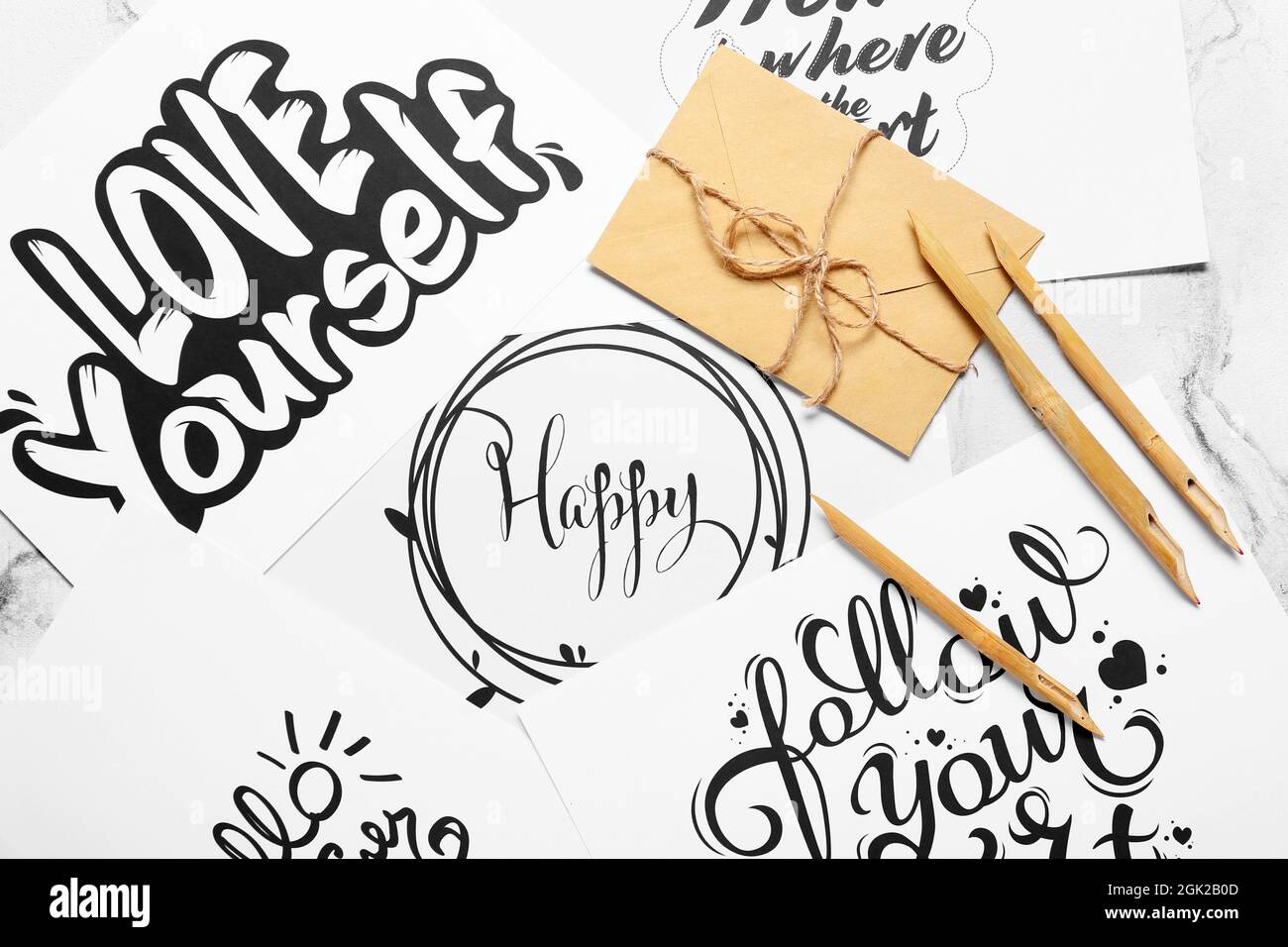 Immergere le penne e le buste su fogli di carta con testi diversi Foto Stock