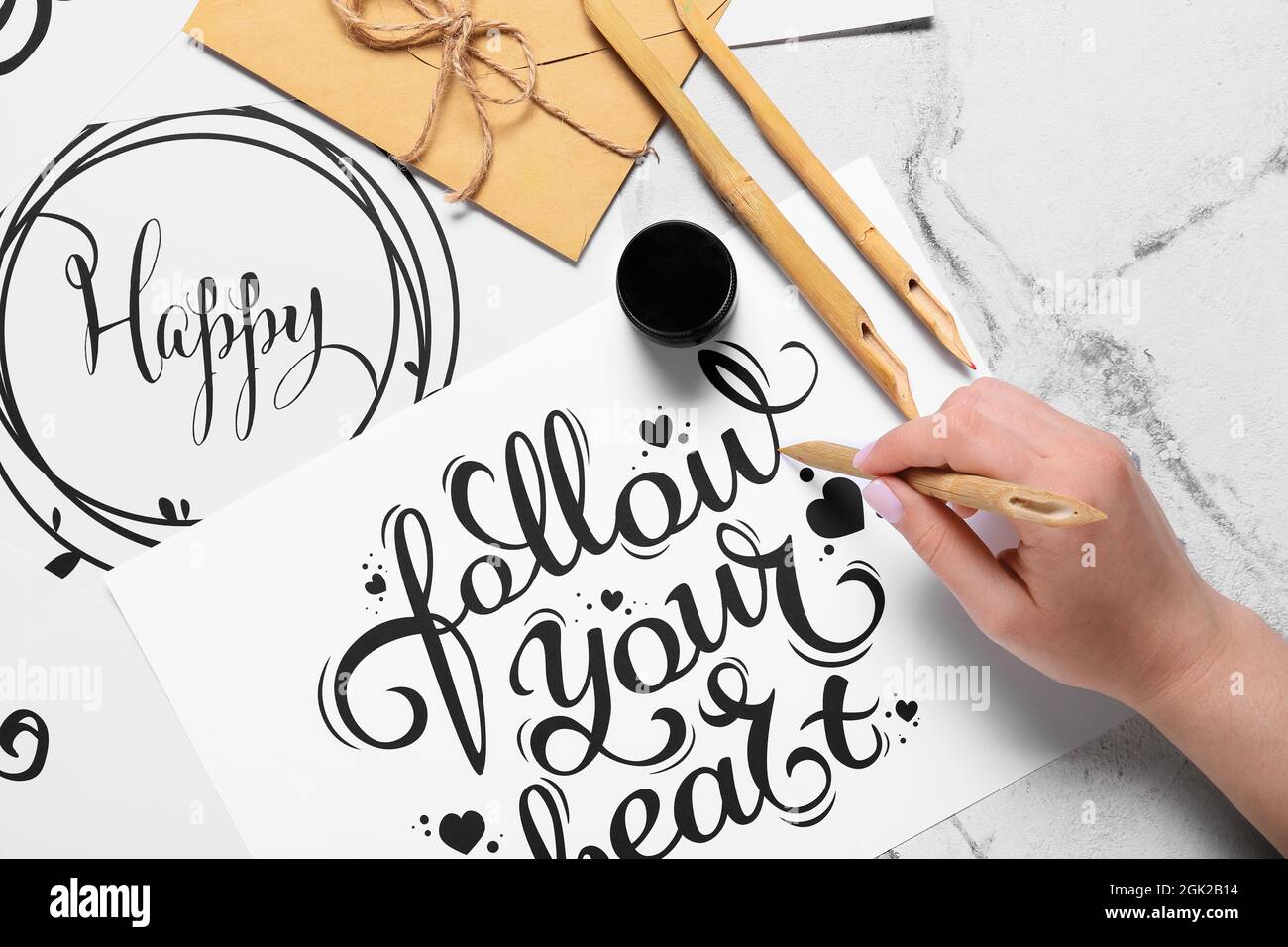 Donna scrittura testo SEGUIRE IL VOSTRO CUORE su sfondo chiaro Foto Stock