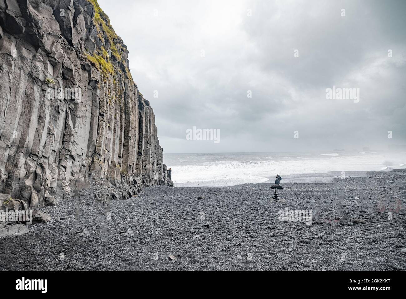 Vista panoramica della grotta sulla spiaggia di Reynisfjara in Islanda con grandi colonne di basalto e spiaggia rocciosa. windi freddo posto in spiaggia con grandi onde. Foto Stock