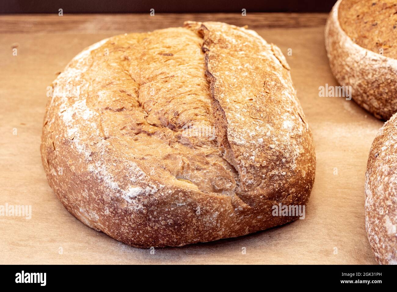 Primo piano di pane fatto in casa marrone, pane scuro marrone con grani sullo scaffale del negozio Foto Stock