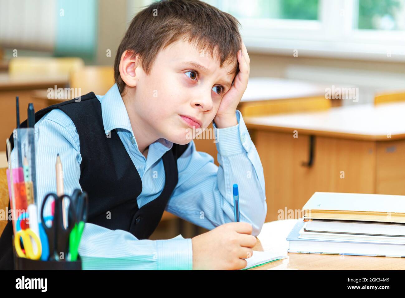 Scolaro serio in classe. Studente della scuola elementare. Ritorno a scuola. Foto Stock