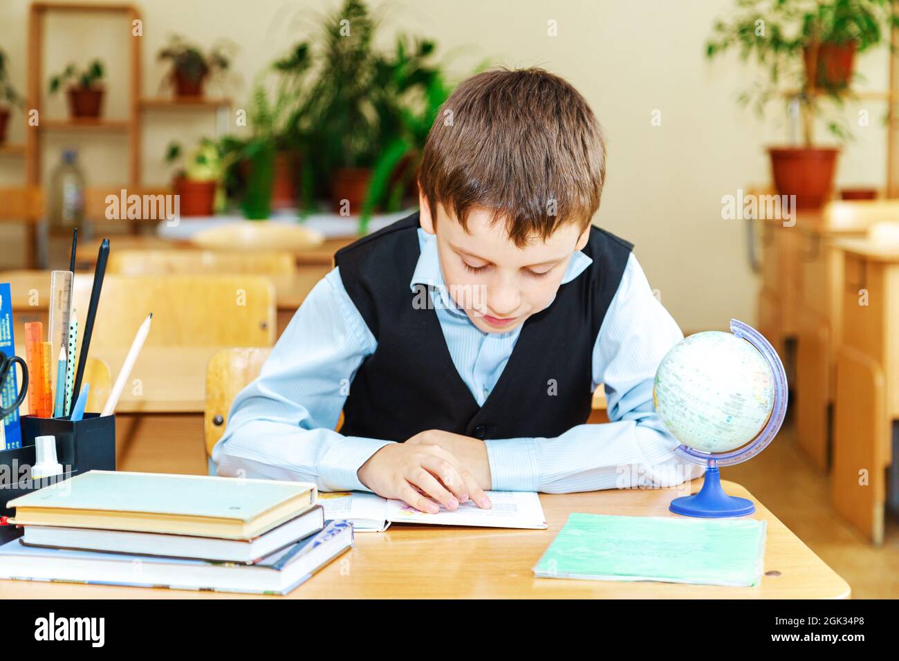 Scolaro serio in classe. Studente della scuola elementare. Ritorno a scuola. Foto Stock