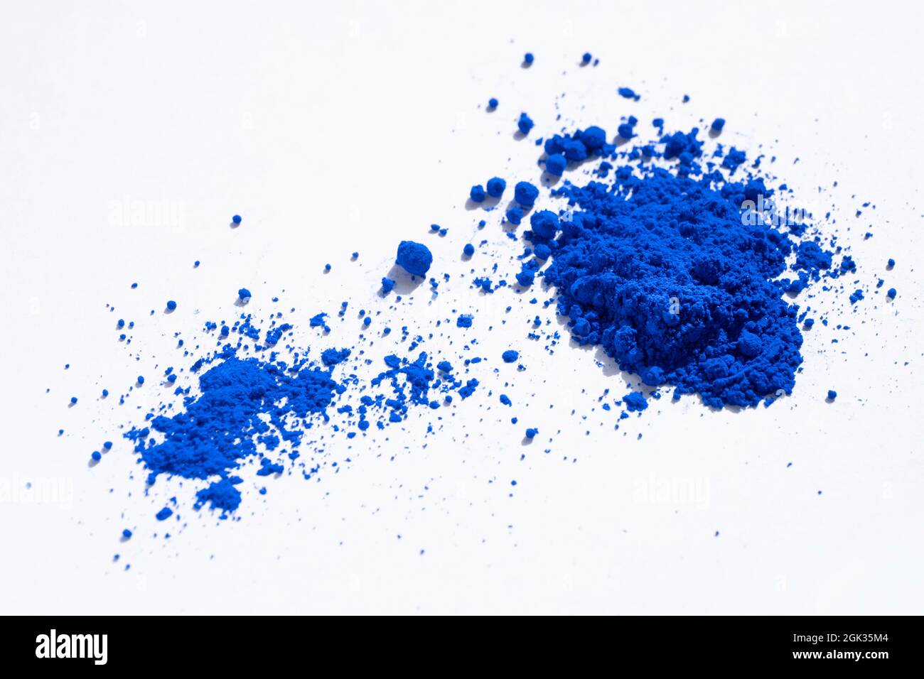 Porzione grande e piccola di pigmento blu ultramarino, cobalto o indaco su bianco. Il pigmento è stato mescolato con olio di lino per produrre la vernice oli Foto Stock