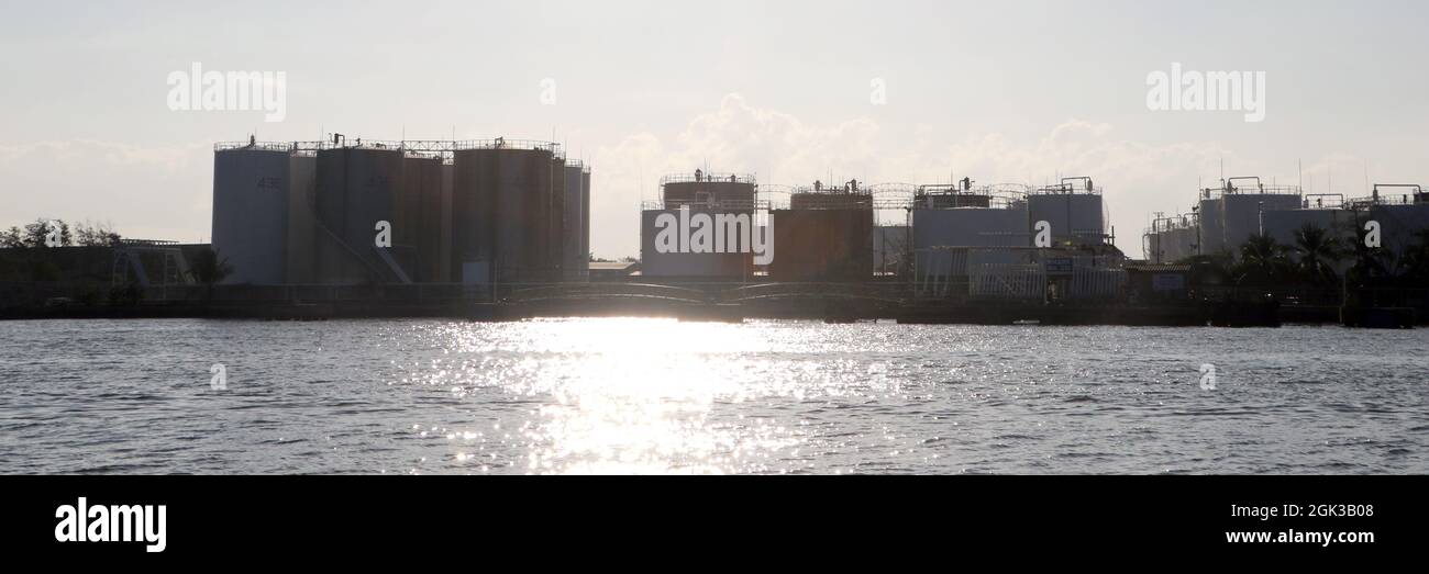 Silhouette, vista posteriore dei serbatoi di stoccaggio del petrolio nel porto di esportazione, il settore petrolifero che esporta con le navi. Foto Stock