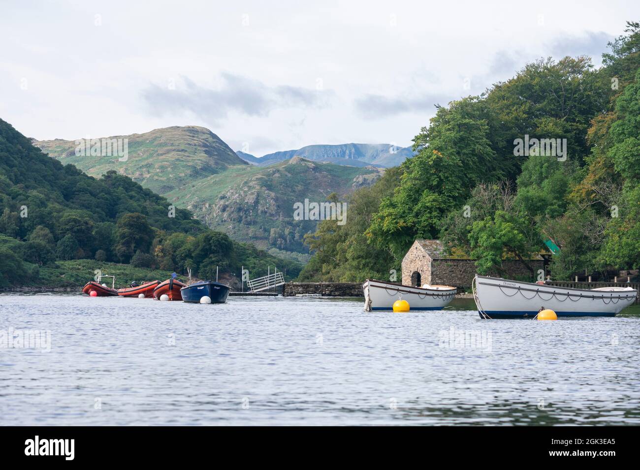 Ormeggiate barche a Ullswater con Helvellyn e montagne dietro, Lake District, Cumbria, Regno Unito Foto Stock