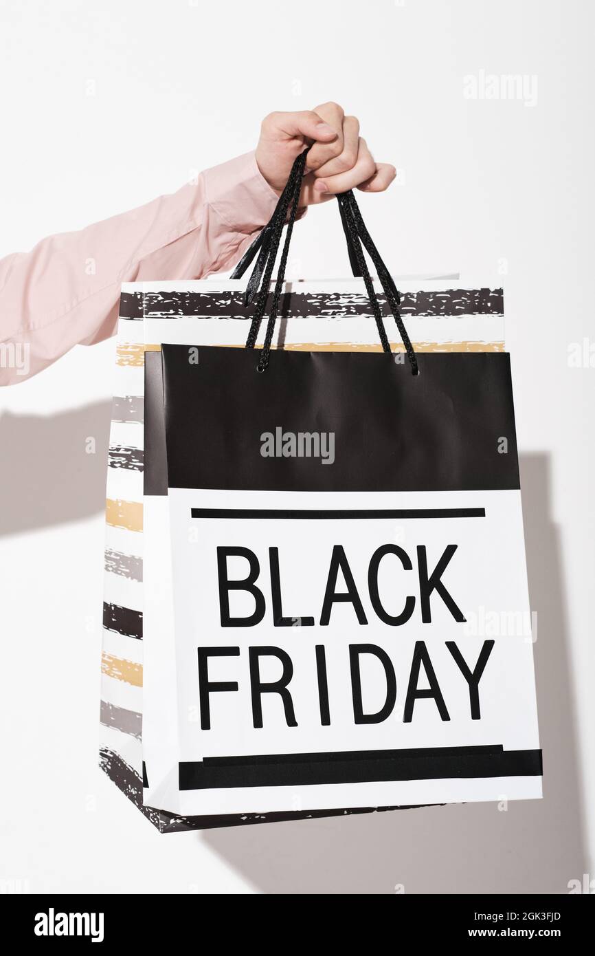 Primo piano dell'acquirente che tiene i sacchetti durante il Black Friday nel negozio Foto Stock