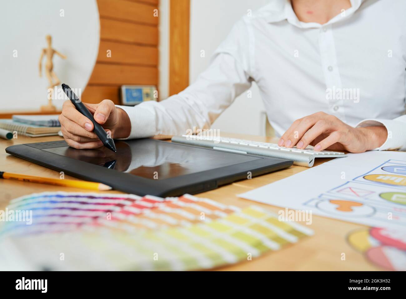 Immagine closeup di un grafico freelance che lavora su un grande progetto per il cliente e disegno con penna digitale Foto Stock