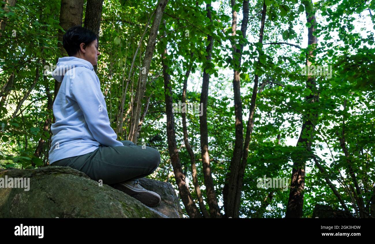 Meditazione e relax della giovane donna in una foresta Foto Stock