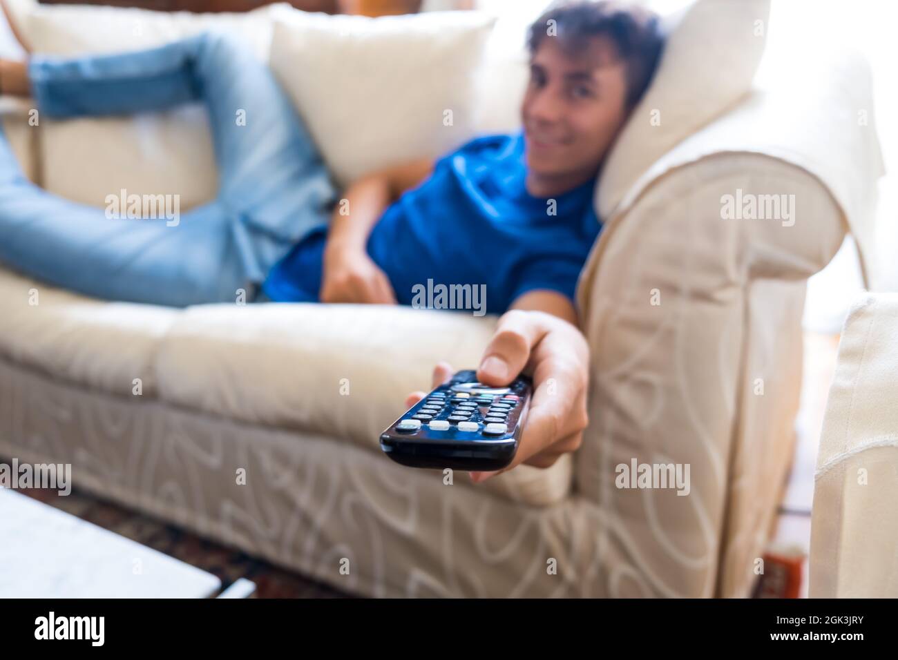 Giovane studente sul divano guardando la televisione a casa - giovani con tecnologia - intrattenimento stile di vita moderno e foto di scorta della scuola Foto Stock