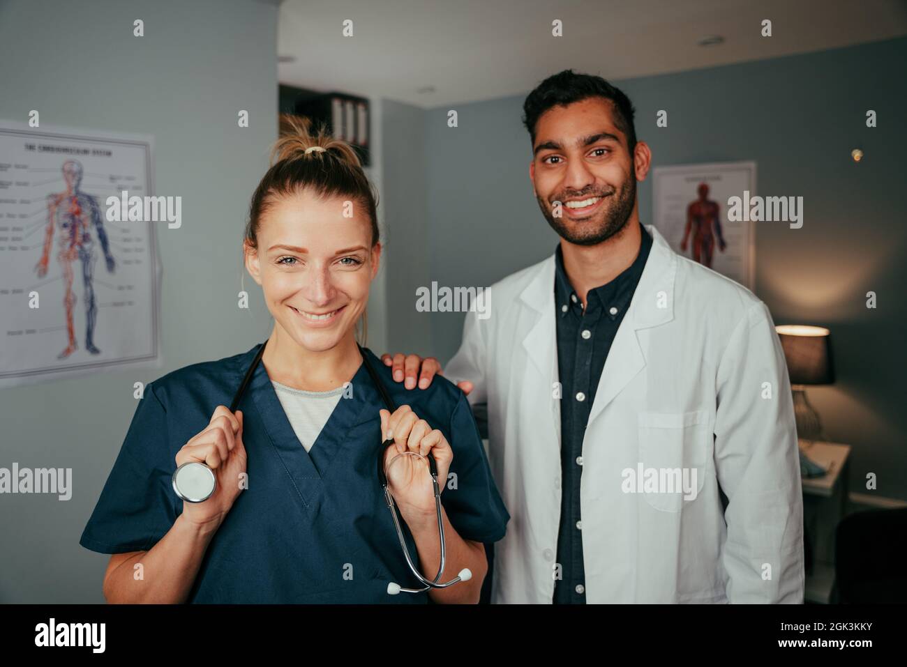 Infermiere caucasico in piedi con chirurgo maschile misto razza Foto Stock