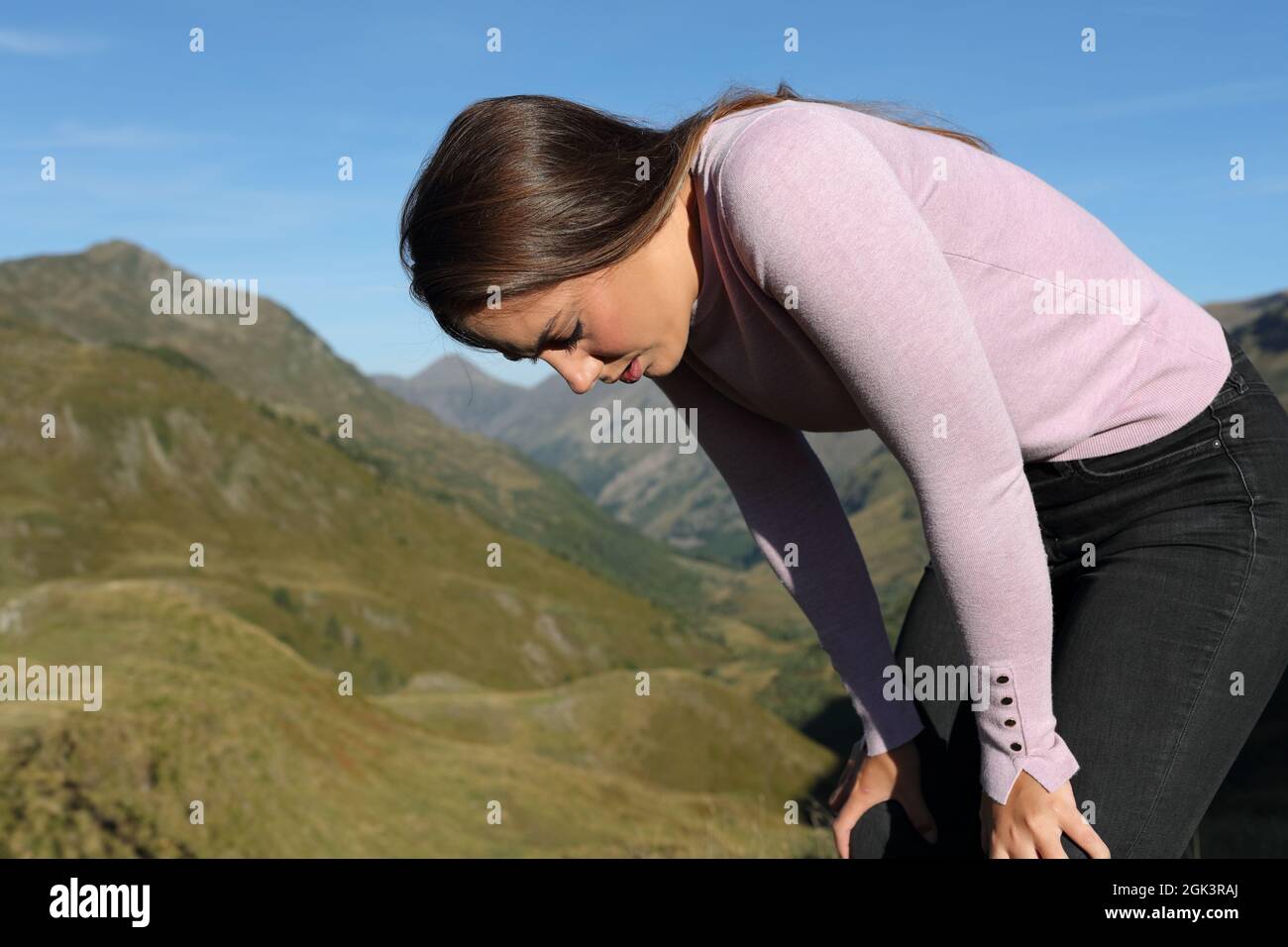 Esausta donna casual riposo dopo aver camminato in montagna Foto Stock