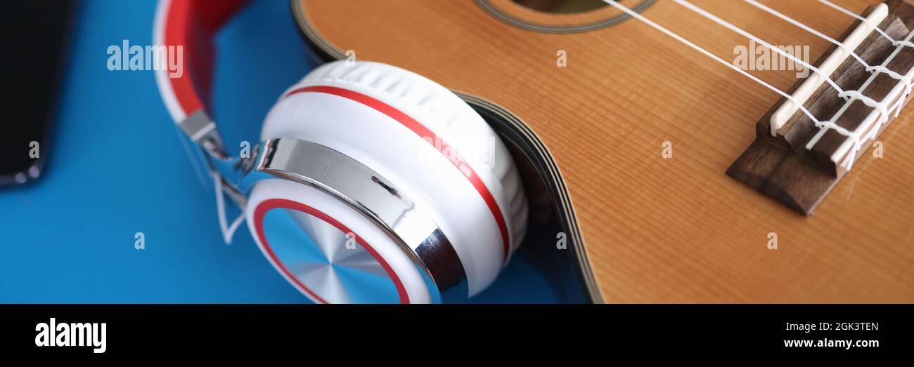 Chitarra acustica con cuffie giace sul tavolo Foto Stock