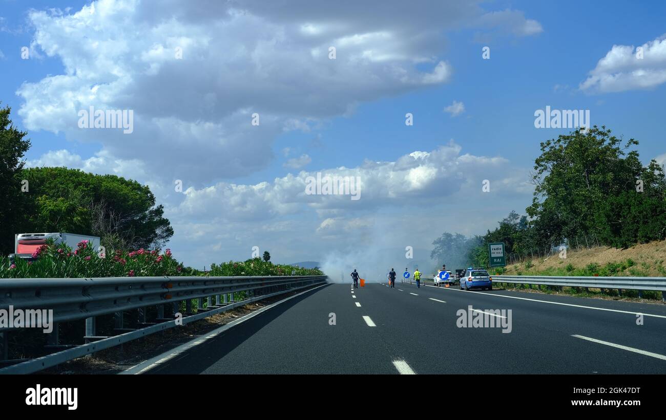 Fuoco sulla strada italiana con vigili del fuoco e polizia Foto Stock