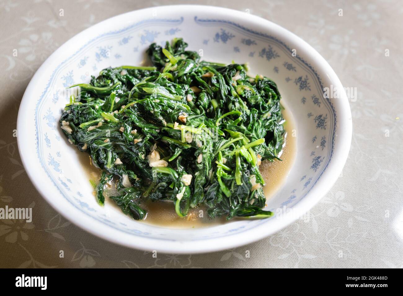 Soffriggere in padella gli spinaci di amaranto verde cinese con aglio e sale, ricchi di nutrienti, proteine e fibre. Foto Stock