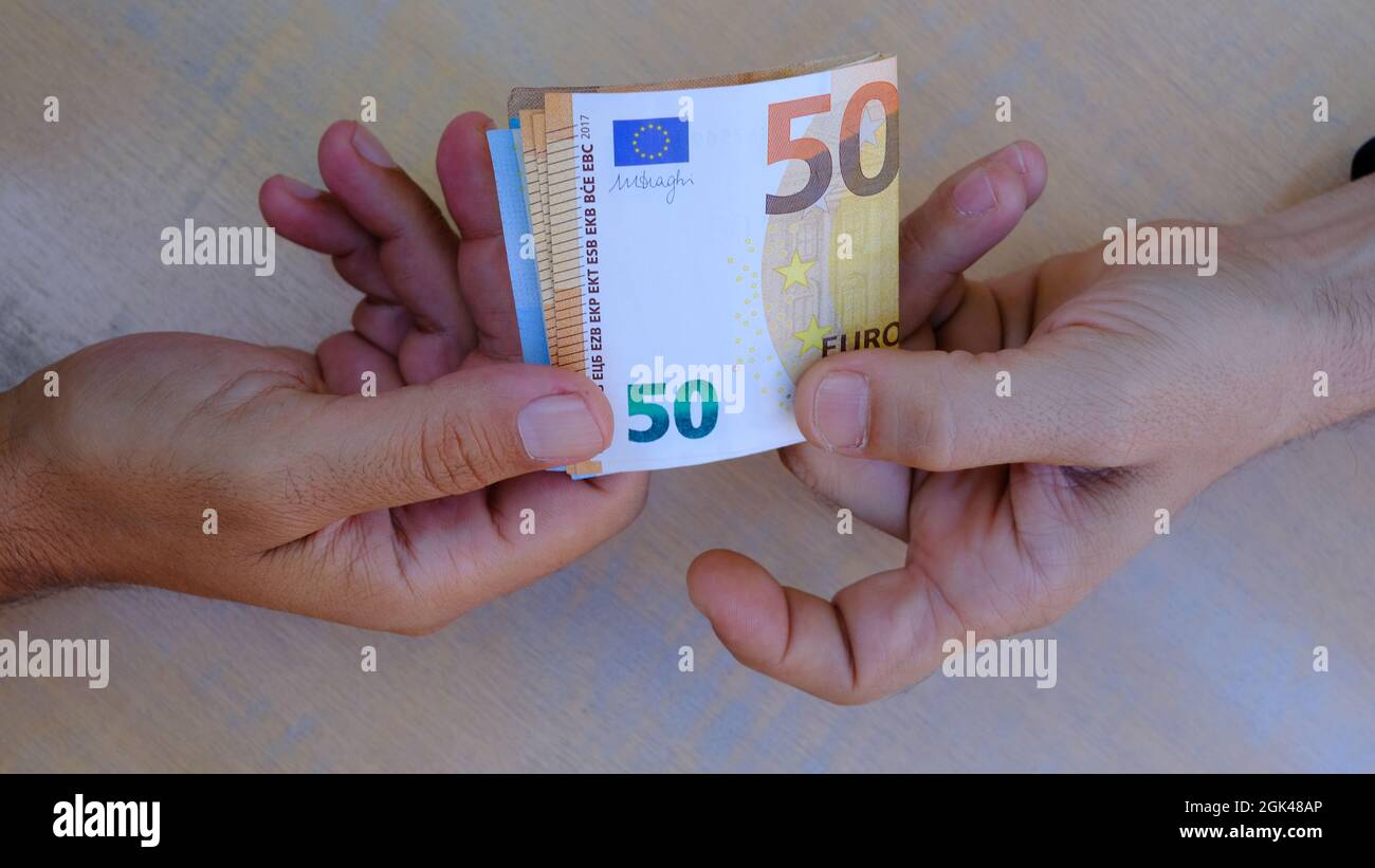 cambio di denaro a mani maschili, banconote in euro Foto Stock