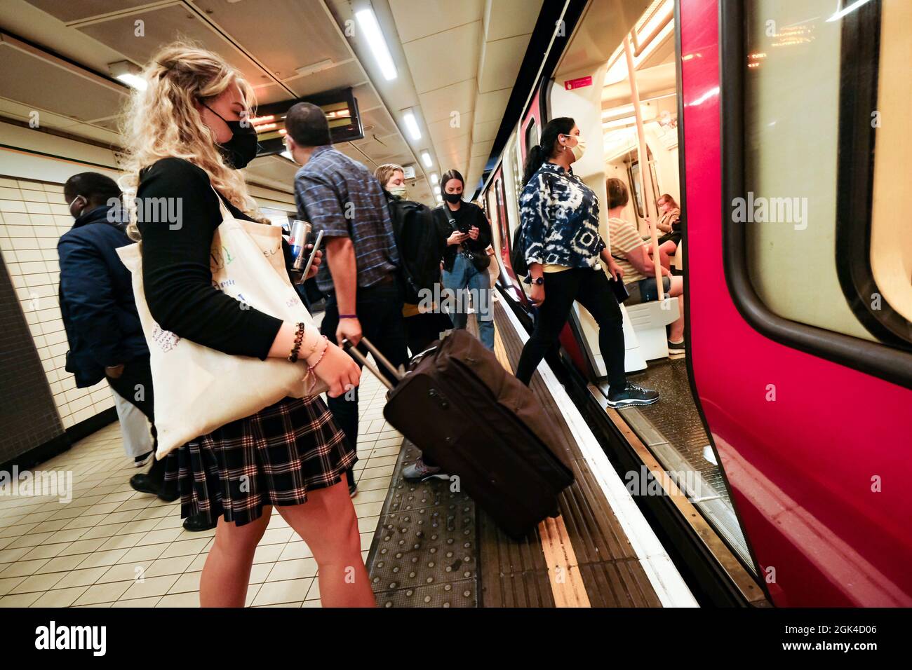 Londra - Luglio 2021: Passeggeri della piattaforma della stazione della metropolitana di Londra che indossano maschere facciali Covid 19 Foto Stock