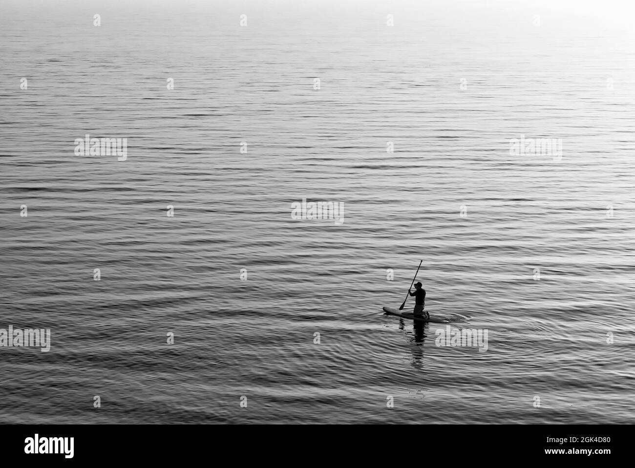 Uomo paddle boarding in mare Foto Stock