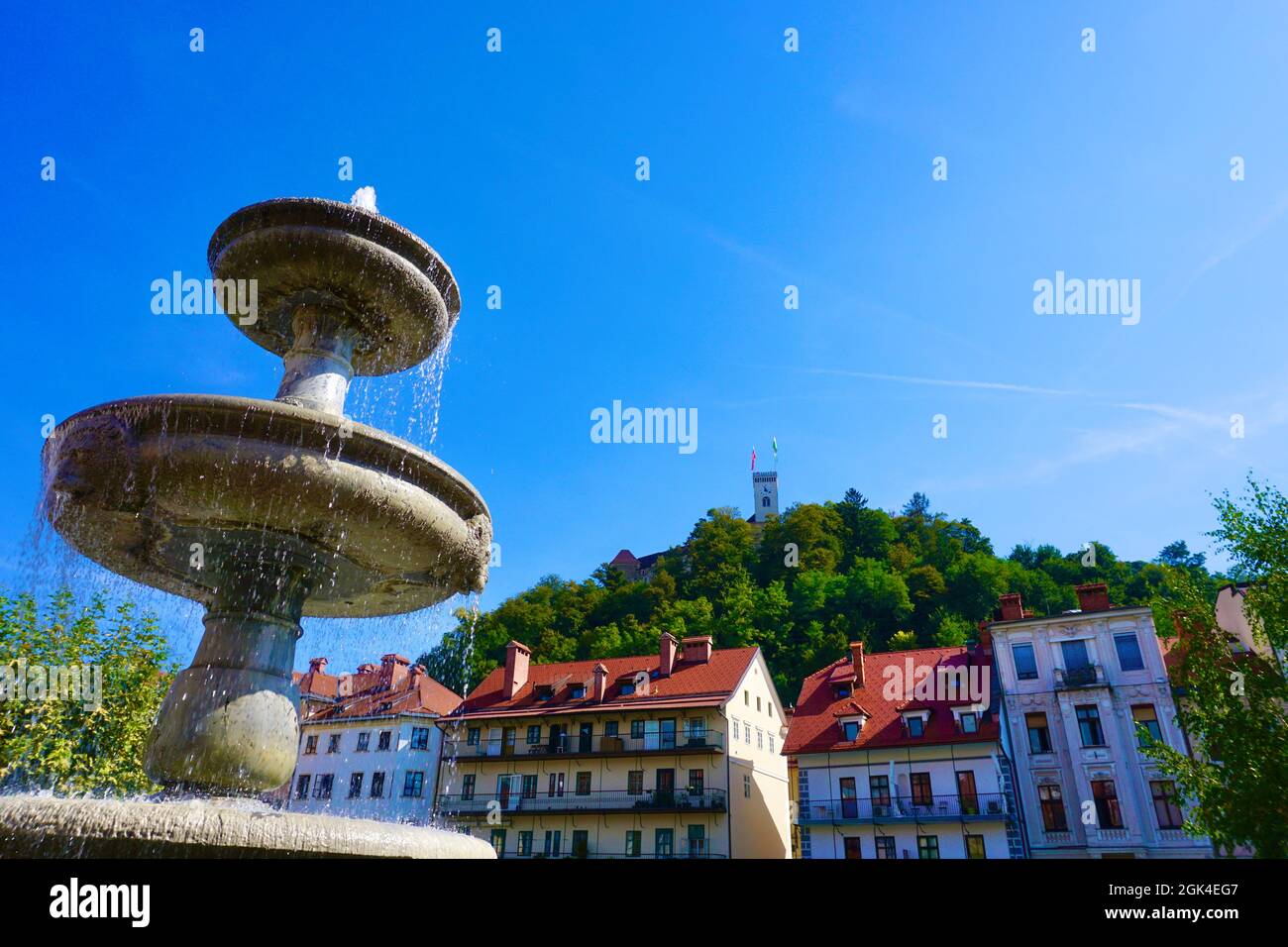Fontana nella città di Lubiana, in Slovenia il giorno d'estate con collina del Castello sullo sfondo Foto Stock