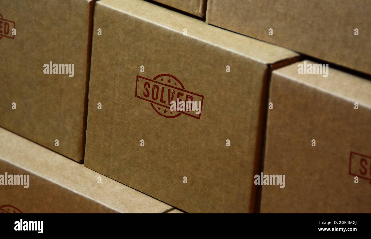 Timbro risolto stampato su scatola di cartone. Concetto di soluzione del problema. Foto Stock Timbro risolto stampato su scatola di cartone. Concetto di soluzione del problema. Foto Stock