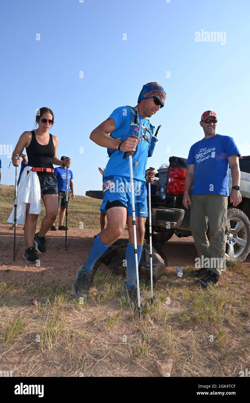 Kyle Knutson, il 177th Intelligence Squadron Commander, North Dakota Air National Guard, a destra, fa il tifo per Senior Master Sgt. Brandon Miller, anche del 177th Intelligence Squadron, mentre corre l'ultima tappa della versione 107.3-miglia del Maah Daah Hey Trail ultramarathon con supporto e ingranaggio membro del team Melissa Haugrud nel bellissimo badlands del North Dakota 1 agosto 2021. Il suo team SAG lo incontra ad ogni checkpoint e gli fornisce cibo, liquidi e attrezzature per rimanere fresco e asciutto tra le fasi della gara. Sta mettendo calzini e scarpe asciutti ad ogni scacchiera Foto Stock