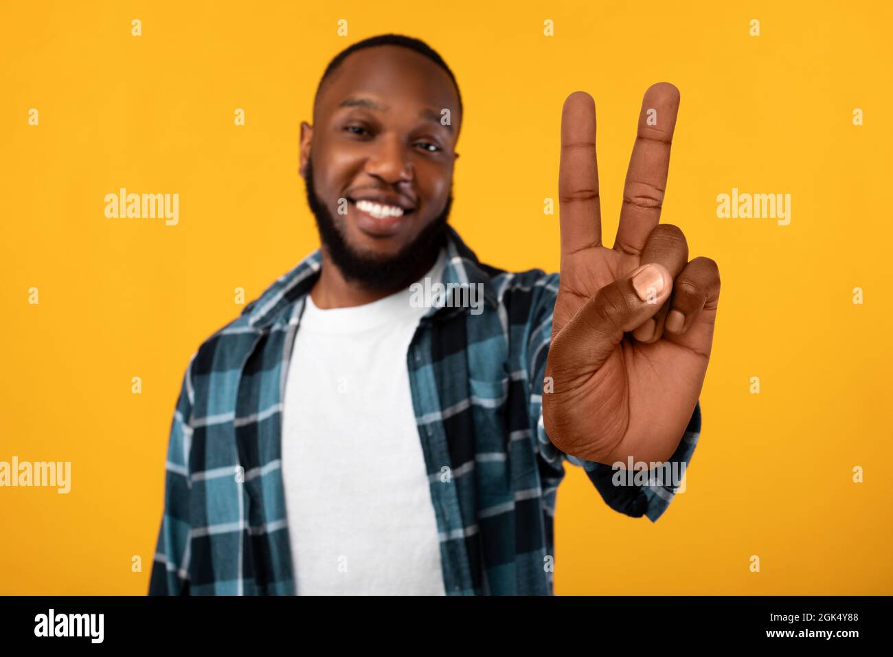 Il Guy afro-americano positivo che mostra il gesto di Pace, Studio Shot Foto Stock