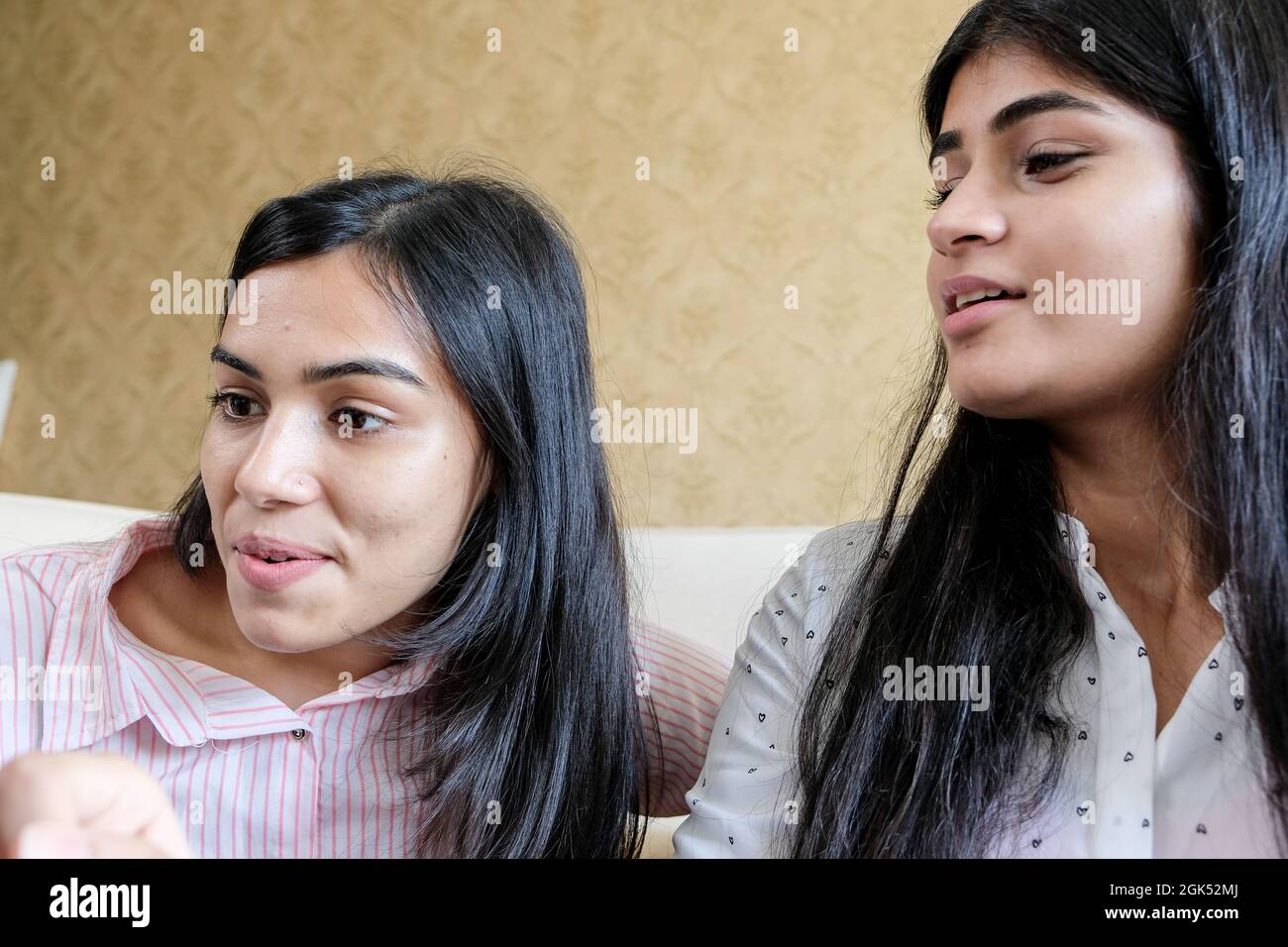 Primo piano girato di due ragazze giovani guardando qualcosa e parlando Foto Stock