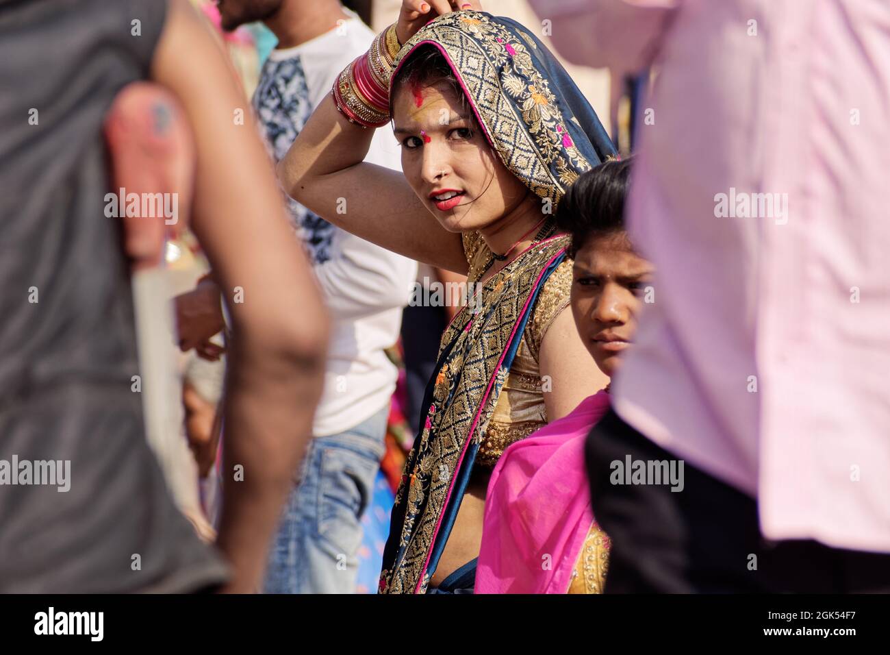 Orchha, Madhya Pradesh, India - Marzo 2019: Una donna indiana che indossa un sari colorato in un mercato affollato durante un festival. Foto Stock