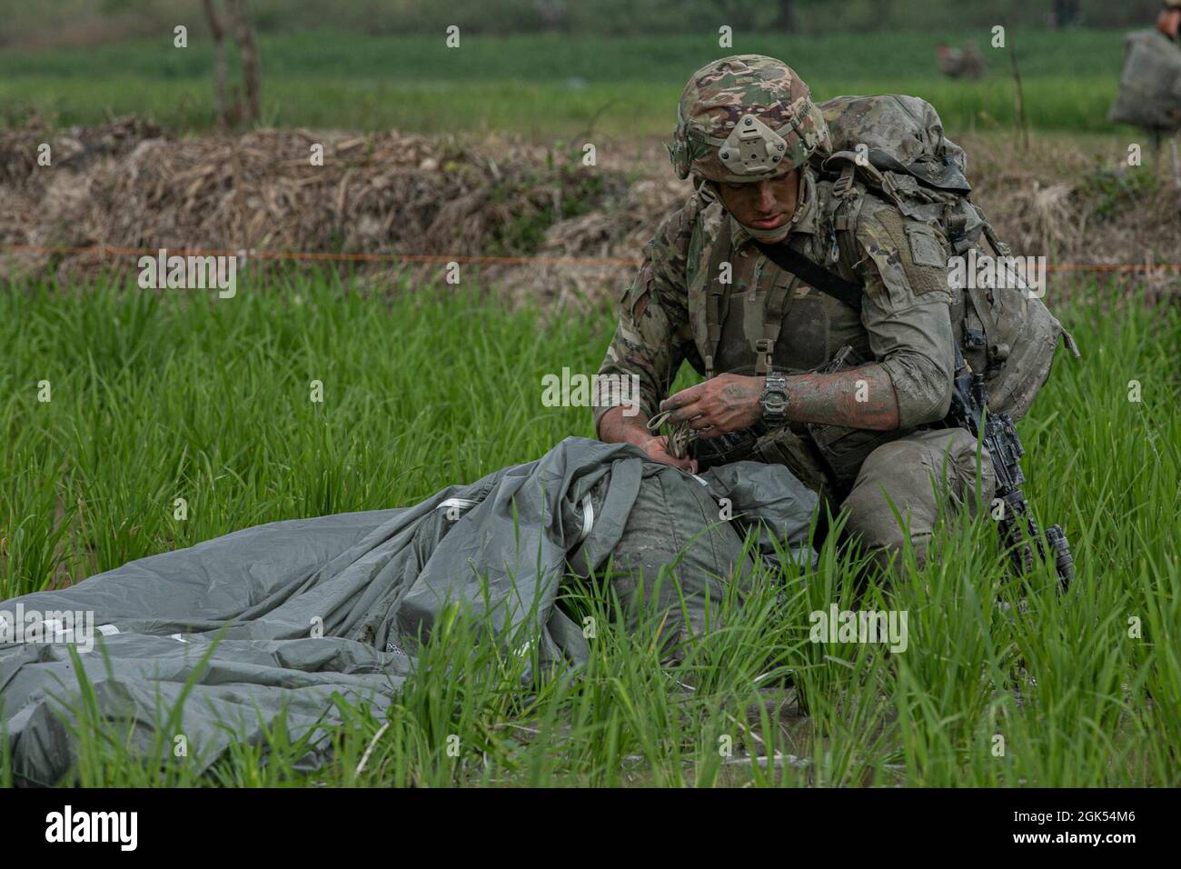 Un soldato dell'esercito degli Stati Uniti con la 82.a divisione di Airborne ripara il suo paracadute dopo aver condotto un'operazione di entrata forzabile congiunta all'area di addestramento di Baturaja, il 4 agosto 2021. Garuda Shield 21 è un'esercitazione congiunta di due settimane tra l'esercito degli Stati Uniti e l'Indonesia di Tentara Nasional (TNI-ad Indonesia Armate Forces). Lo scopo di questo esercizio congiunto è quello di migliorare e arricchire la capacità di guerra nella giungla sia dell'esercito degli Stati Uniti che dell'esercito indonesiano. Foto Stock