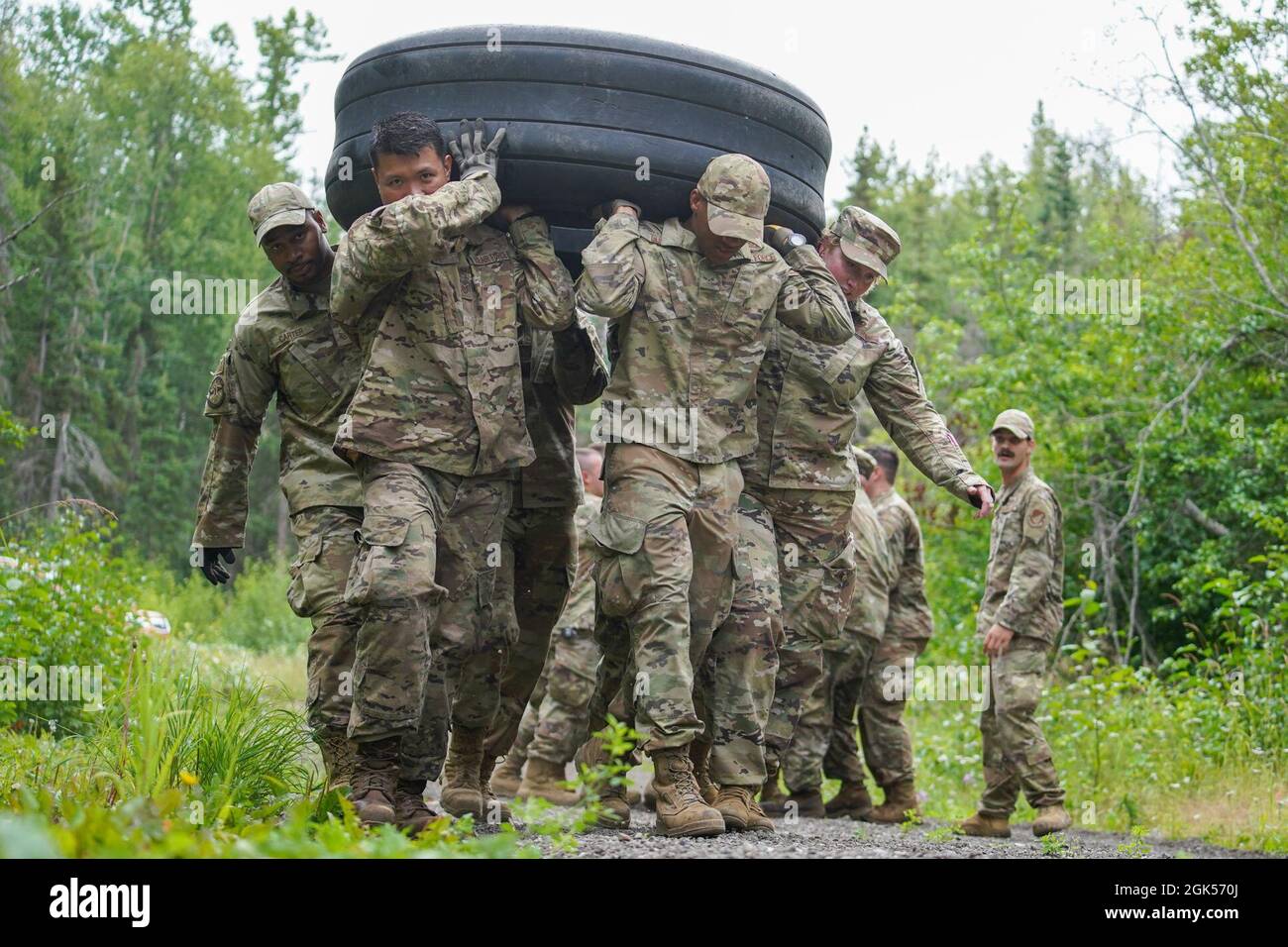 Gli airmen assegnati al 773d Civil Engineer Squadron lavorano insieme per spostare un pneumatico attraverso una stazione senza rotolarlo durante il primo ingegnere base forza di emergenza, o prime BEEF, programma al Camp Mad Bull sulla base congiunta Elmendorf-Richardson, Alaska, 4 agosto 2021. Gli Airmen hanno lavorato in piccole squadre sul corso sugli ostacoli multi-stazione per prepararsi alle situazioni che potrebbero incontrare mentre si trovano in un ambiente implementato. Foto Stock