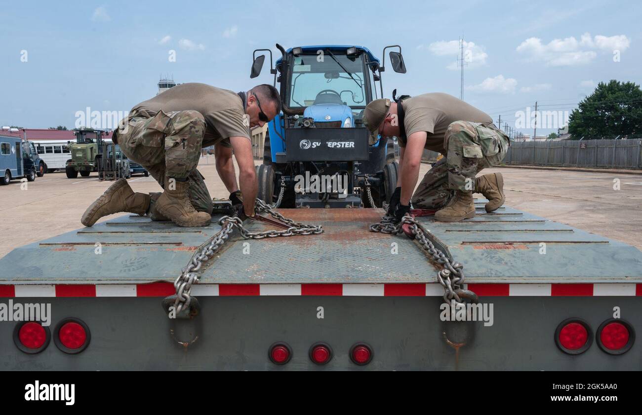 Gli airmen del 2nd Logistics Readiness Squadron si preparano a rimuovere un trattore da un camion a pianale alla base dell'aeronautica di Barksdale, Louisiana, 9 agosto 2021. I professionisti del trasporto a terra dell'aeronautica mantengono i veicoli di base e forniscono le opzioni di trasporto per le varie agenzie di base. Foto Stock