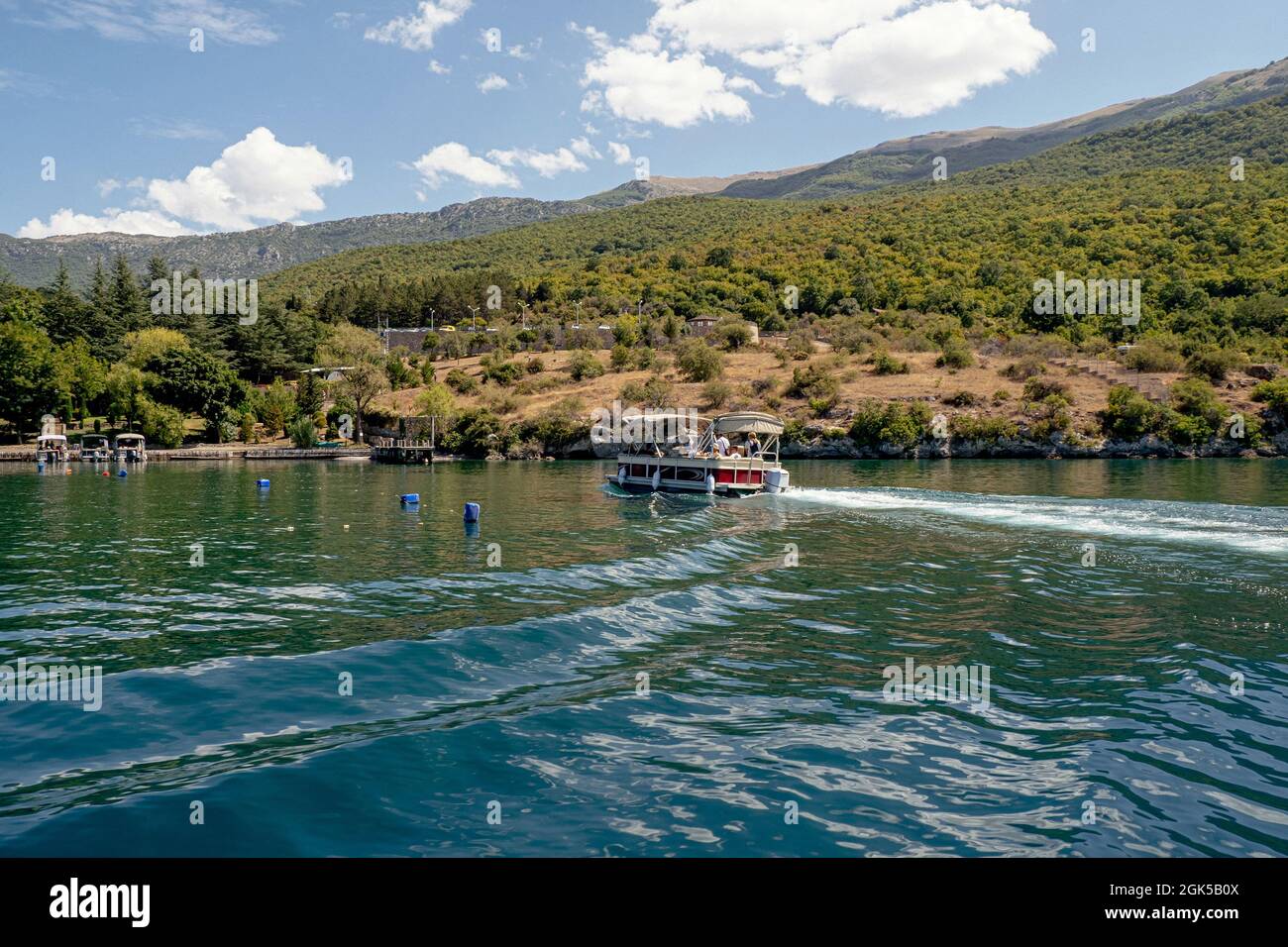 Barca con i turisti vela riva sul lago di Ohrid Foto Stock