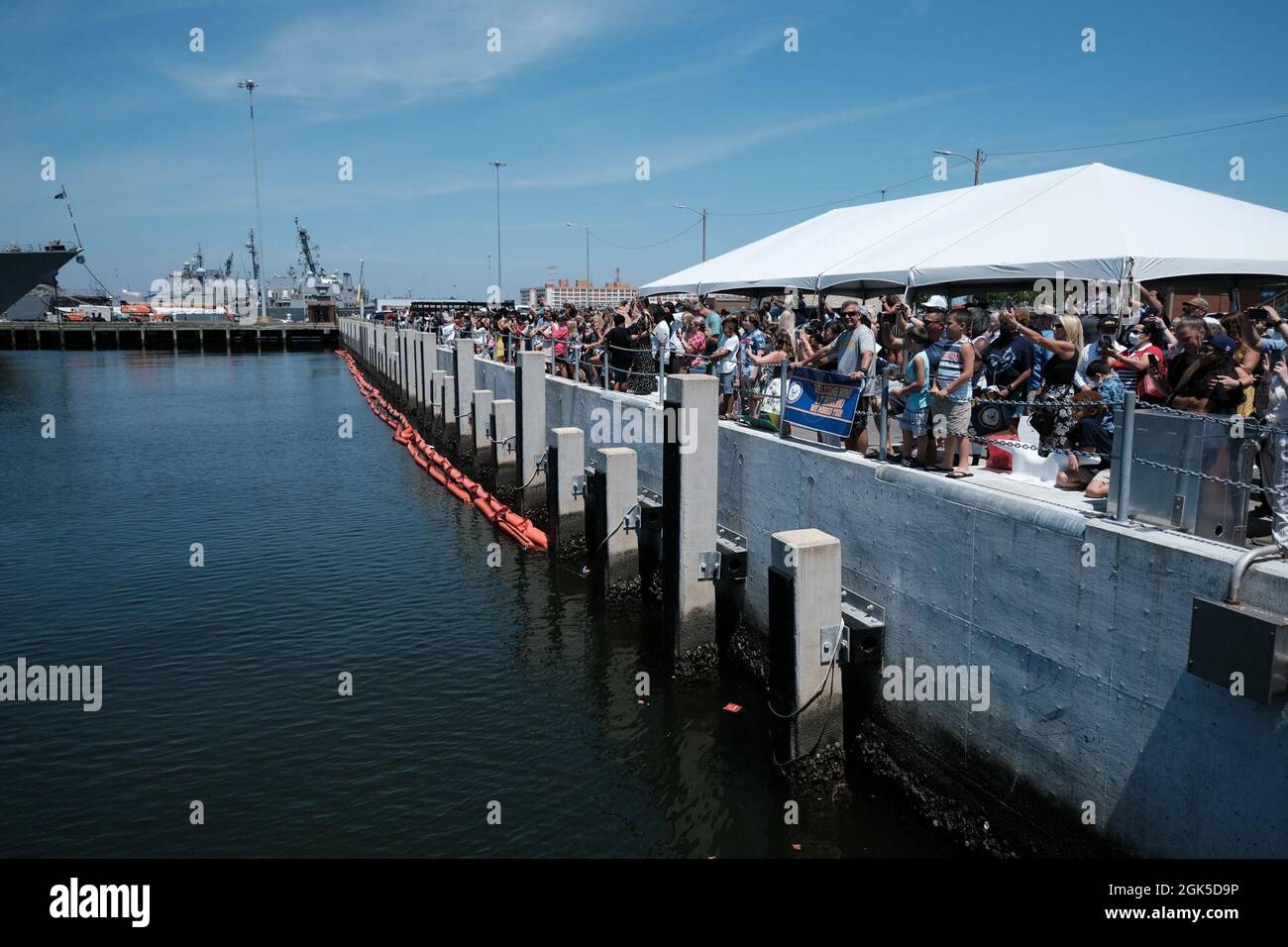 NORFOLK, Virginia (agosto 6, 2021) – le famiglie attendono il ritorno del cacciatorpediniere missilistico guidato di classe Arleigh Burke USS Mahan (DDG 72). Mahan, una nave del gruppo di Strike della portante di Eisenhower (IKE CSG) è ritornata a homeport nella stazione navale di Norfolk 6 agosto, dopo un dispiegamento di sei mesi alle aree di funzionamento della flotta degli Stati Uniti 5 e 6. Foto Stock