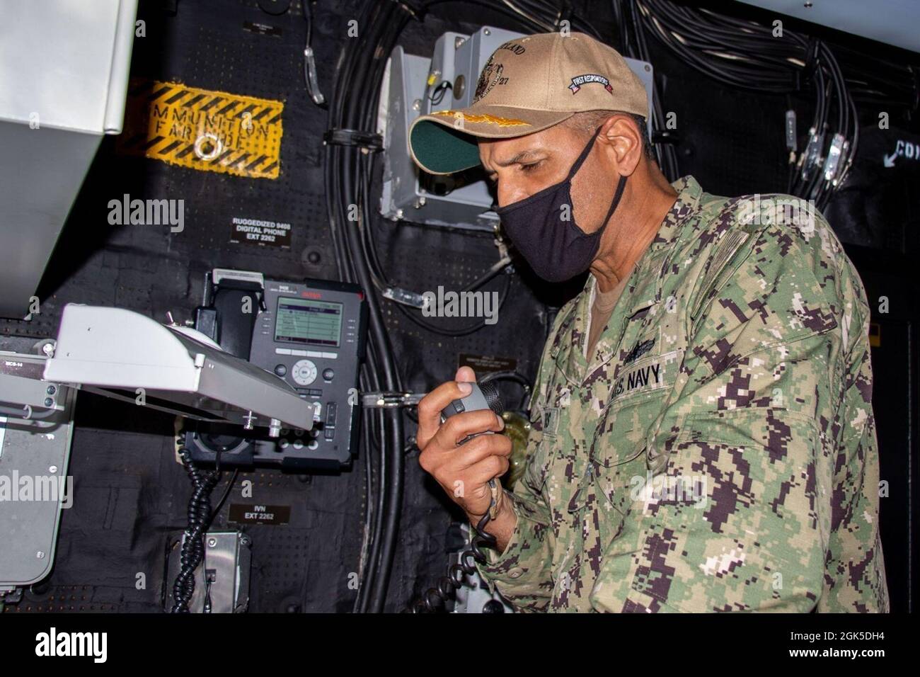 Il Capitano Karrey Sanders, comandante della nave portuale anfibio USS Portland (LPD 27), commenta il sistema di annuncio della nave prima di relinquire il comando al Capitano Matthew Thomas durante una cerimonia di cambio comando, 6 agosto. Portland sta conducendo operazioni di routine nella terza flotta statunitense. Foto Stock