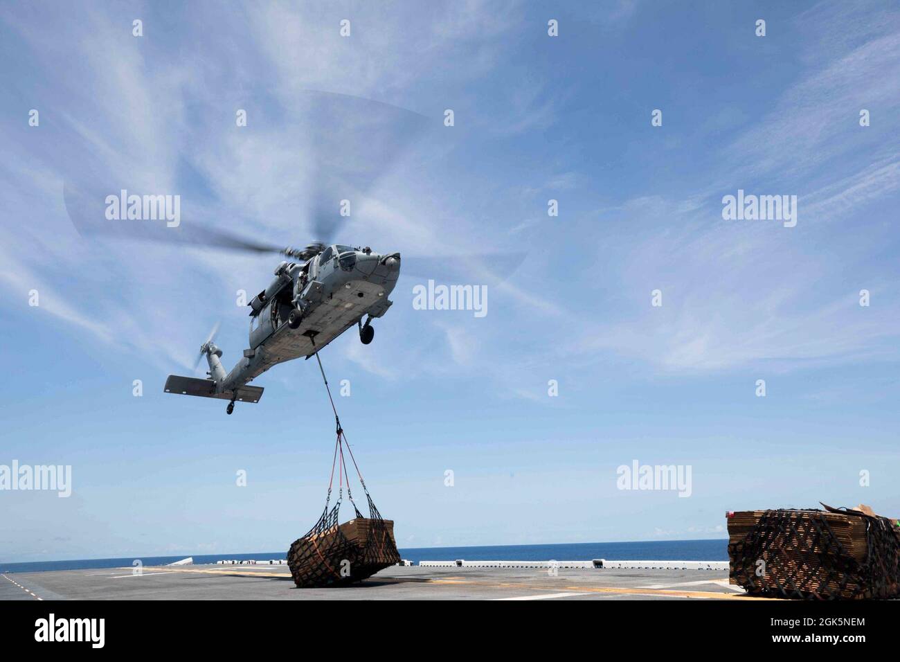 Piloti della Marina degli Stati Uniti con elicottero Sea Combat Squadron 28, forniture di trasporto da USNS Arctic (T-AOE-8), utilizzando MH-60S Seahawk Helicopters durante un rifornimento in mare (RAS), a bordo della nave d'assalto anfibio Wasp-Class USS Kearsarge (LHD 3), 9 agosto 2021. RAS viene condotto per trasferire beni di prima necessità come munizioni, forniture e cibo da una nave all'altra mentre è in corso. Foto Stock