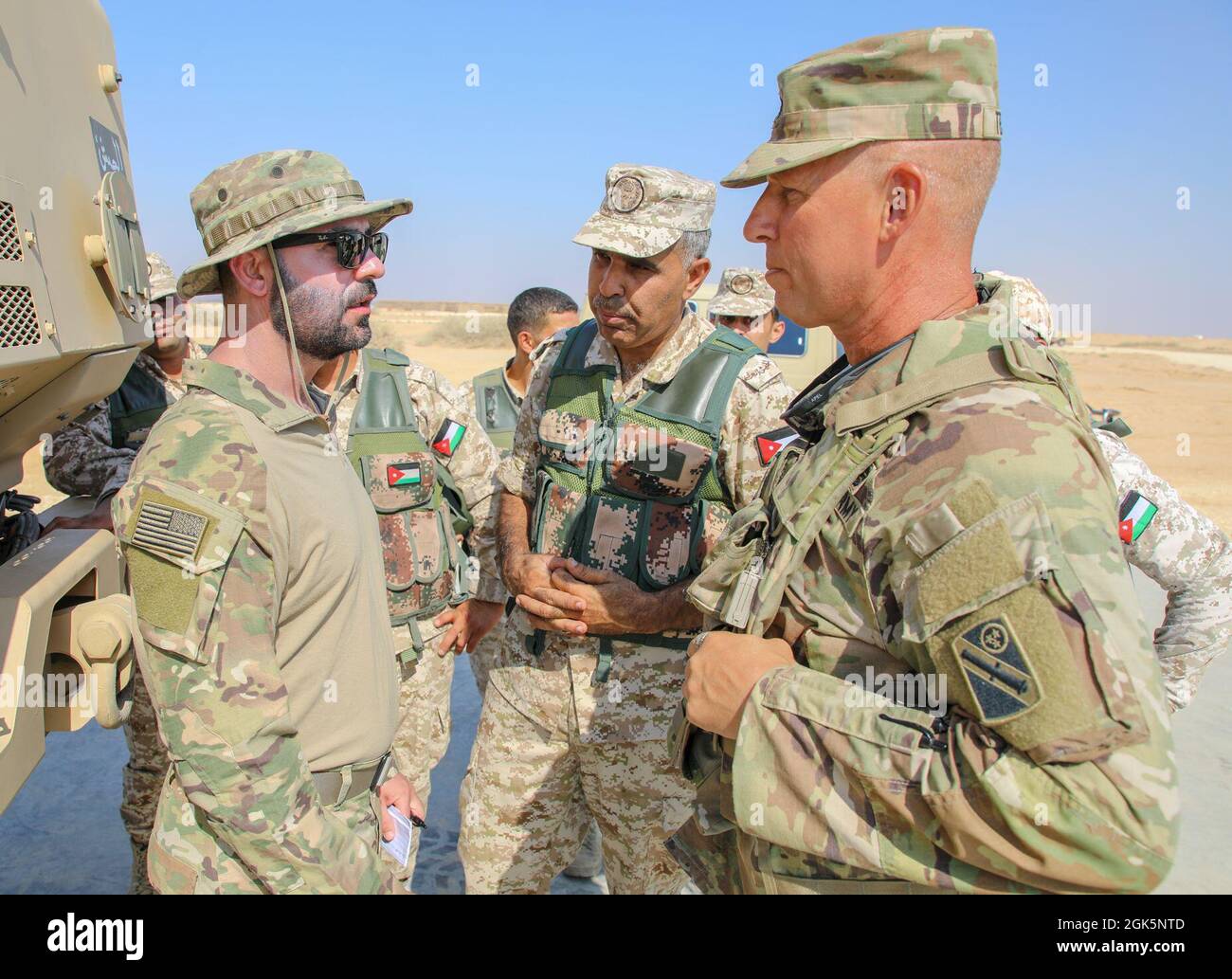 Il personale dell'esercito degli Stati Uniti Sgt. Jeff Tesmer, assegnato alla Task Force Iron Valor, parla con le forze Armate reali giordane durante la Redleg Tempest, il 9 agosto 2021 in Giordania. Redleg Tempest è un esercizio di formazione per il personale dell'artiglieria. Foto Stock