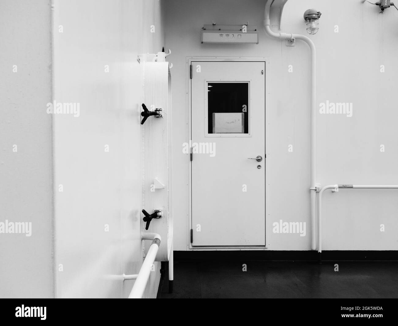 Bianco pulito nave moderna porta chiusa pianale nero ponte con valvola a griglia di ventilazione sulla parete Foto Stock