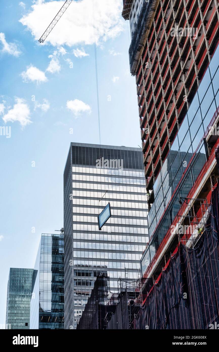 Gru da cantiere che guida un gigantesco vetro del vetro per l'installazione in un grattacielo sulla Fifth Avenue, New York City, USA 2021 Foto Stock