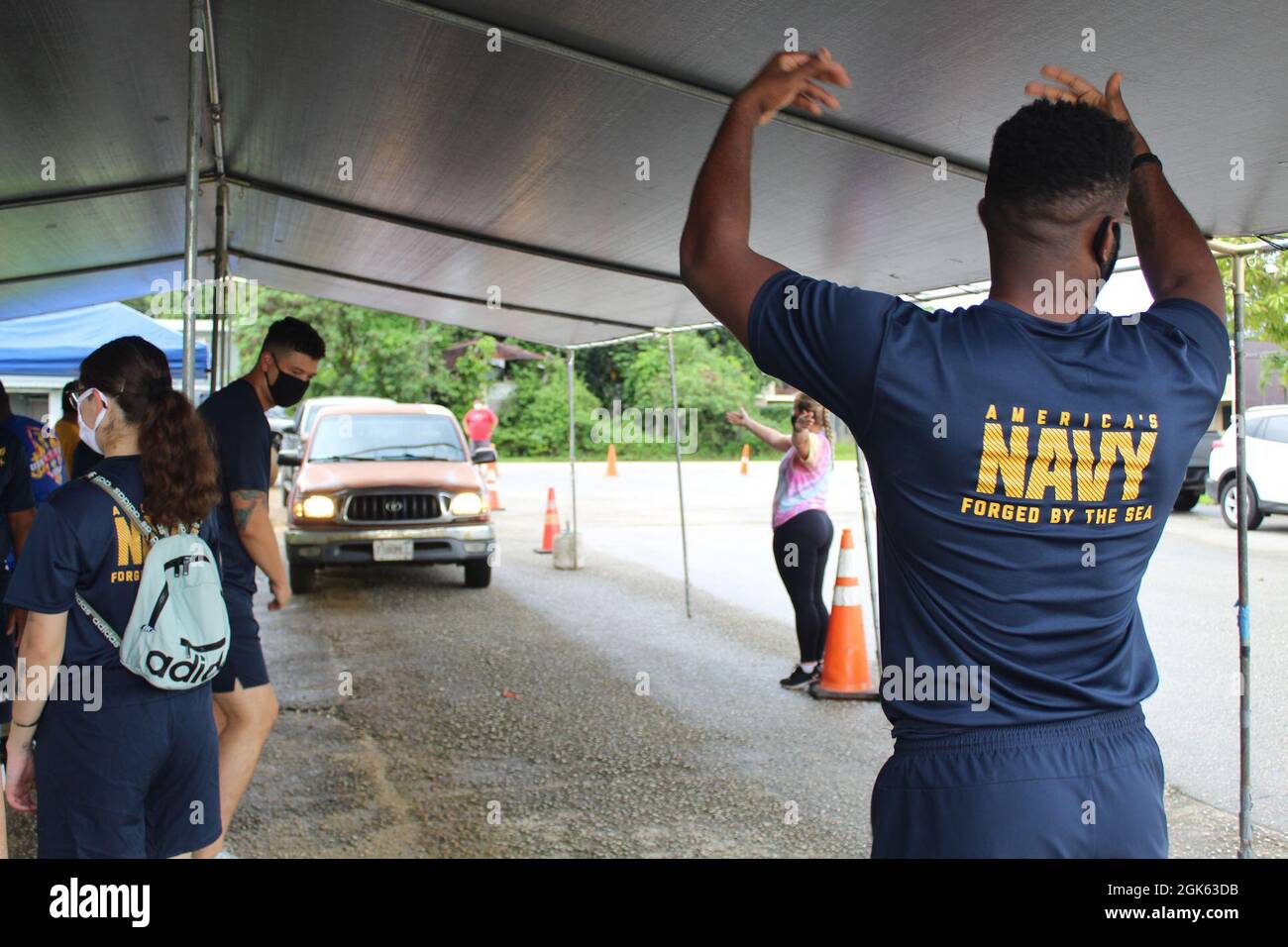 AGAT, Guam (agosto 13, 2021) - i marinai di USS Emory S. Land (AS 39) e Visiting Marines of Combat Logistics Regiment 17 (CLR-17) si sono offerti volontariamente all’Ufficio del Sindaco di Agat per distribuire 400 pacchetti di prodotti alimentari nell’ambito del programma di assistenza alimentare d’emergenza (TEFAP), agosto 12. Le materie prime sono rese possibili attraverso il Guam Department of Education attraverso il Dipartimento dell'Agricoltura degli Stati Uniti Food Nutrition Service e sono distribuite dai sindaci del villaggio a famiglie bisognose e colpite dalla pandemia COVID-19. Il 9 agosto, volontari del Land e CLR 17 hanno confezionato le 400 confezioni di cibo Foto Stock