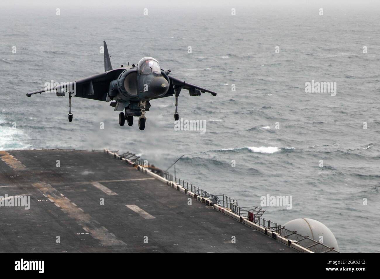 210812-N-OJ308-1095 GOLFO DI OMAN (AGOSTO 12, 2021) un AV-8B Harrier, attaccato al Marine Medium Tiltrotor Squadron (VMM) 162 (rinforzato), atterra sul ponte di volo della nave d'assalto anfibio di classe Wasp USS Iwo Jima (LHD 7), Agosto 12. Iwo Jima è schierata nella 5th Fleet area degli Stati Uniti di operazioni a sostegno delle operazioni navali per garantire la stabilità e la sicurezza marittima nella regione centrale, collegando il Mediterraneo e Pacifico attraverso l'Oceano Indiano occidentale e tre punti di arresto strategici. Foto Stock