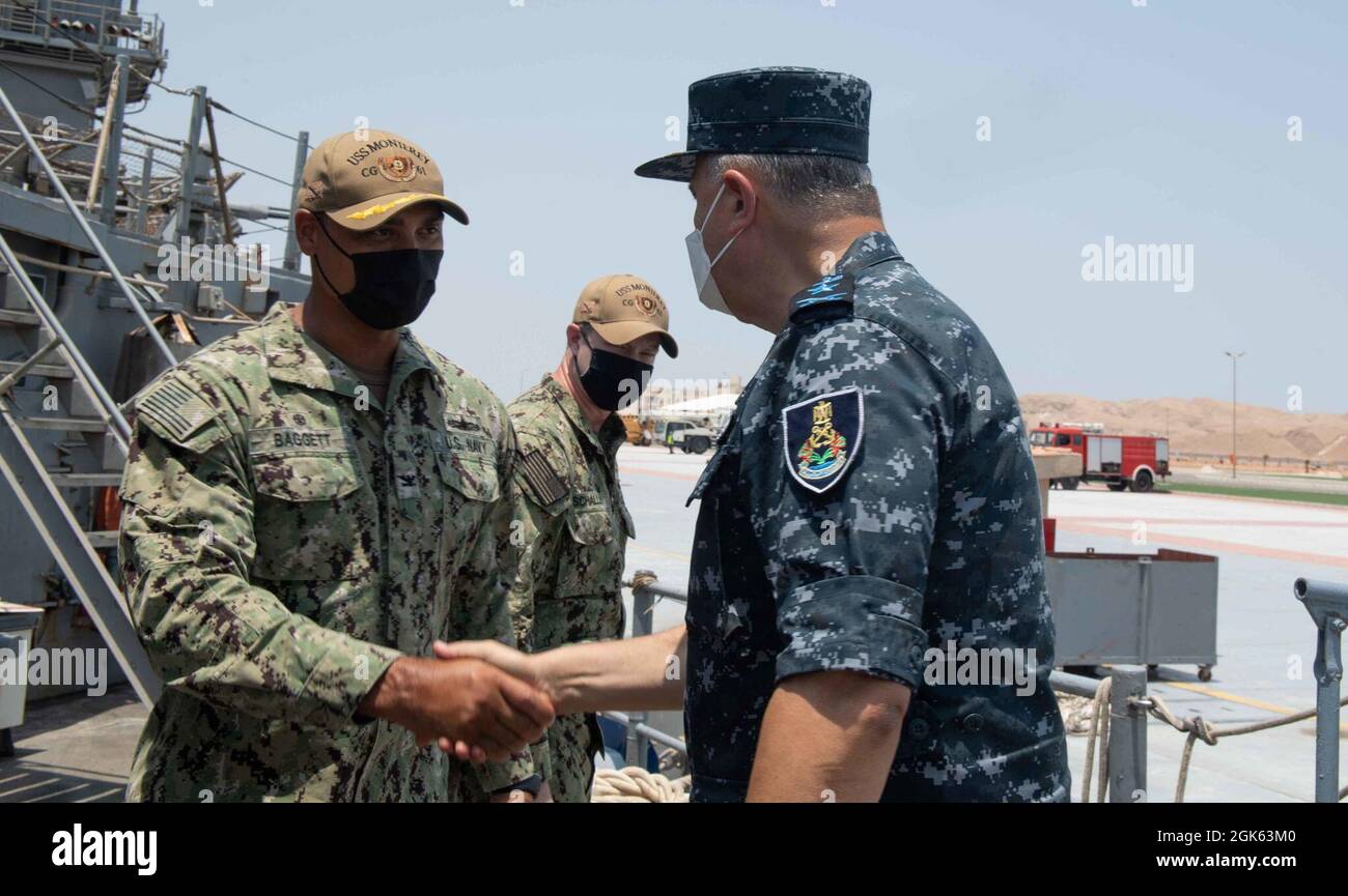 210812-N-WQ732-1016 BERENICE, Egitto (12 agosto 2021) – Capt Joseph Baggett, comandante dell'incrociatore missilistico guidato USS Monterey (CG 61), a sinistra, greets Vice ADM. Ahmed Khaled Hassan Saeed, comandante della forza navale egiziana, durante un giro della nave a Berenice, Egitto, 12 agosto. Monterey è schierata nella 5th Fleet area degli Stati Uniti di operazioni a sostegno delle operazioni navali per garantire la stabilità e la sicurezza marittima nella regione centrale, collegando il Mediterraneo e il Pacifico attraverso l'Oceano Indiano occidentale e tre punti di arresto strategici. Foto Stock