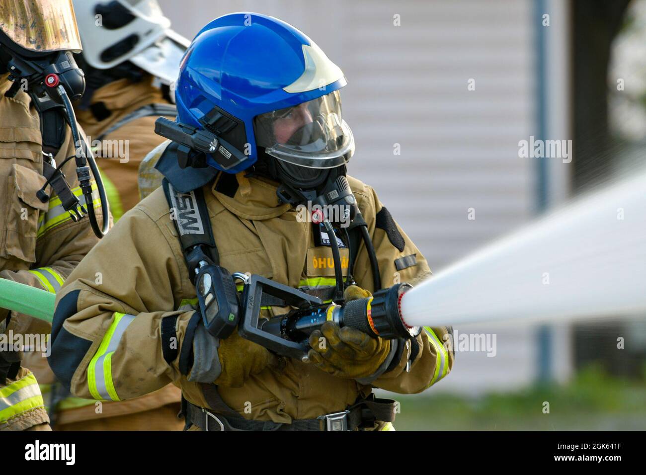 Un vigile del fuoco delle forze armate nazionali lettoni tiene una manichetta mentre spruzza acqua su un fuoco simulato dell'aereo all'Alpena Combat Readiness Training Center, Michigan, 12 agosto 2021. La simulazione faceva parte dell'esercizio Northern Strike 21-2, che offre l'opportunità di costruire l'interoperabilità con altre unità e partner multinazionali, formando al contempo ambienti multi-dominio realistici. Foto Stock