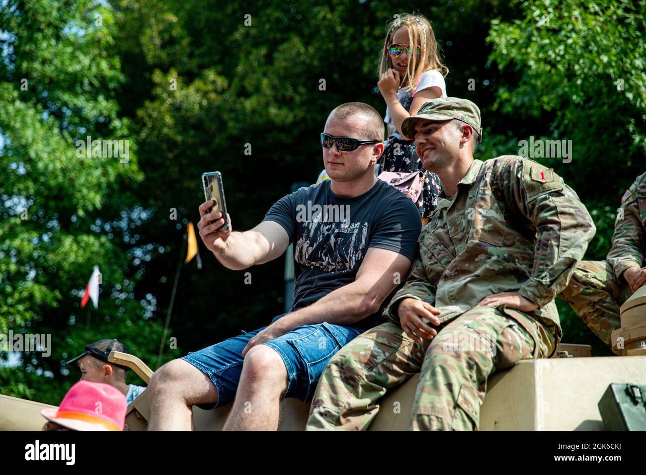 Anthony Gonclaves con la prima Brigata Armored, la prima Divisione di fanteria, pone per una foto con un cittadino polacco in cima ad una M1 Abrams durante una vetrina di veicoli militari e si incontra e saluta a Varsavia, Polonia, 15 agosto 2021. Il Battle Group si unì ai polacchi per celebrare la Giornata delle forze armate polacche e la nostra alleanza NATO. Foto Stock