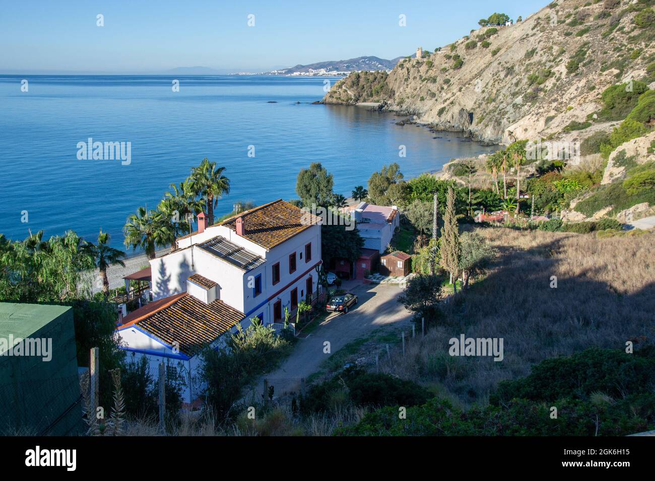 Spiaggia di Cañuelo de Nerja vista dall'alto con una casa e la torre di guardia sullo sfondo. Scogliere di Maro Cerro Gordo Foto Stock