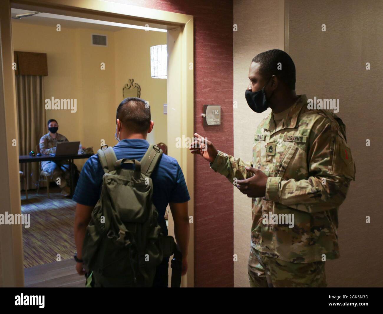 LAFAYETTE, L. – United S. Army Sgt. Prima classe Demarius Pringle, un membro del team di supporto di area in avanti della prima brigata di supporto della Divisione di fanteria, dirige un membro del team di supporto medico della Marina dal comando preparazione e addestramento di Medicina della Marina Bethesda al SPC. Karen Romo, anch'esso assegnato al 1st ID SB, per l'elaborazione, 17 agosto 2021, in un'area di operazioni congiunte durante le operazioni di risposta COVID a Lafayette, Louisiana. Il comando del Nord degli Stati Uniti, attraverso l'Esercito del Nord degli Stati Uniti, rimane impegnato a fornire supporto flessibile del Dipartimento della Difesa alla risposta COVID-19 dell'intero governo. Foto Stock