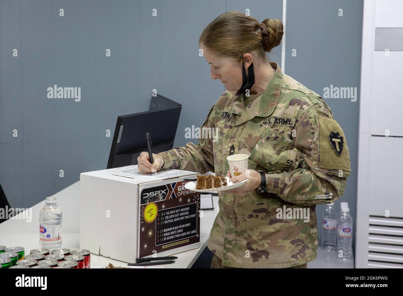 U.S. Army Master Sgt. Latina Stover, chirurgo di divisione per la 36a Divisione di fanteria, compila il suo nome su una latta per avere la possibilità di vincere l'attrezzatura tattica gratuita in occasione della grande apertura del Deutscher Service PX Tactical Store a Camp Arifjan, Kuwait, 18 agosto 2021. La merce al DSPX proviene in gran parte da fornitori tedeschi, ma contiene anche prodotti americani, greci, francesi e scozzesi. Foto Stock